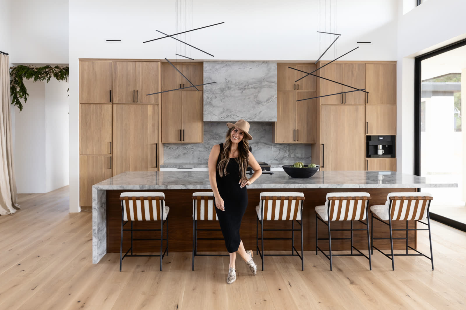 Kim Worswick standing at the marble island of a finished modern kitchen